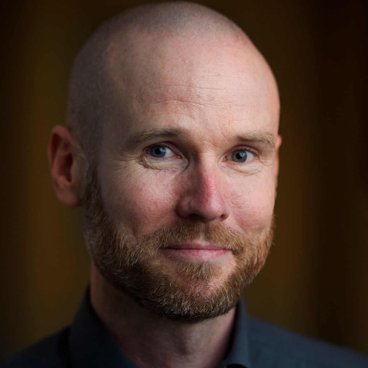 Portrait von Sören Reichardt, Managing Director, vor dunklem Hintergrund
